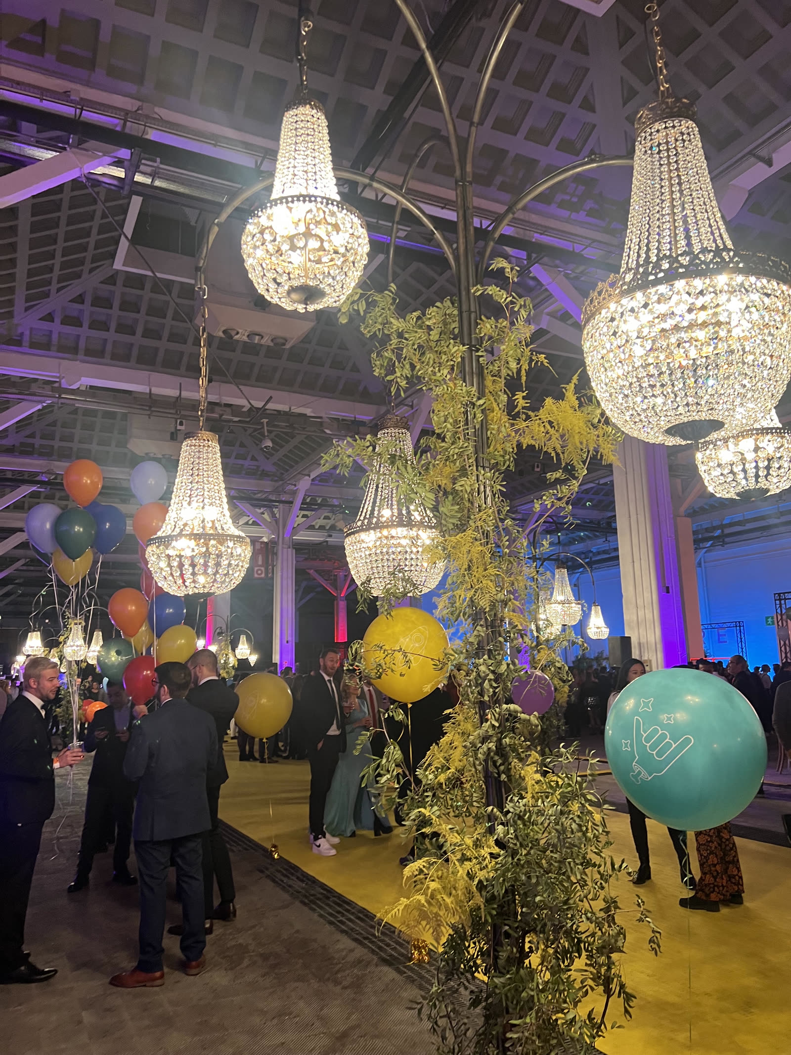 Large-scale event with chandeliers and greenery